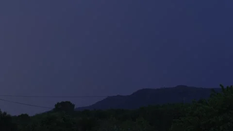 Dramatic Dusk Mountain Landscape with Storm Clouds and Faint Distant Lightning Stock Footage 337442398
