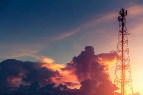 Dramatic dusk sky colorful cloud with communication signal tower silhouette. Stockfoto's