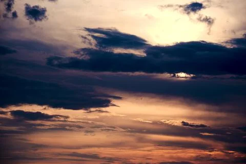 Dramatic dusk sky with many dark clouds and sunbeams Stock Photos