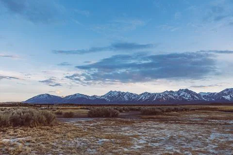 Dramatic Dusk sky over Arid plains against Sierra Nevada Mountains Stock Photos