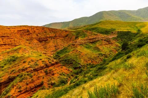 Dramatic Eroded Rock Formations and Green Hills in Kyrgyzstan Foto stock