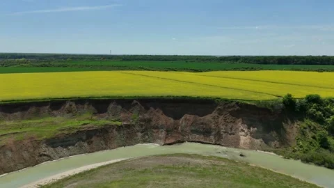 Dramatic Erosion Landscape with Yellow Rapeseed Fields and Meandering River Video stock 312254457