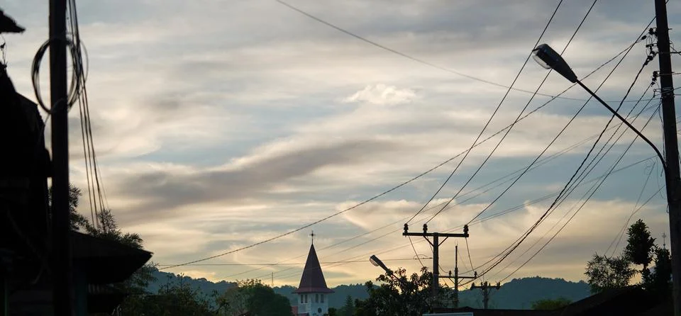 Dramatic Evening Sky Above Rural Town with Power Lines and Church Steeple Stock Photos