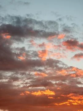 Dramatic evening sky with layered orange and gray clouds Фото