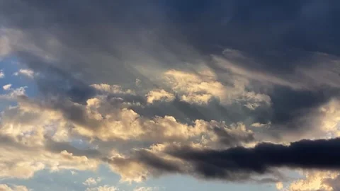 Dramatic evening sky with warm cloud highlights, darks behind, pan left Video stock 286167999