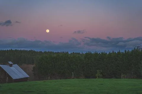 Dramatic Evening sky with yellow moon rising over County scene Stock Photos
