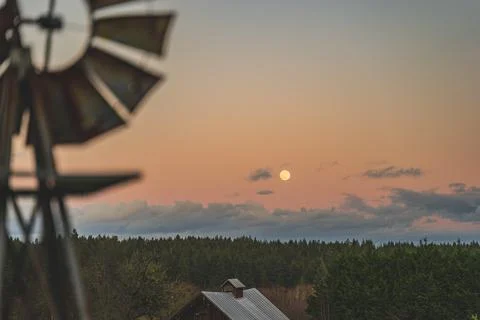 Dramatic Evening sky with yellow moon rising windmill silhouette foreground Stock Photos