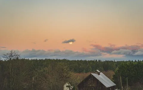 Dramatic Evening sky with yellow moon rising over County scene 写真素材