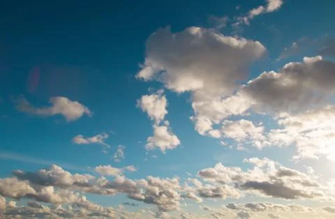 Dramatic evening summer or early autumn warm bright blue cloudy sky background. Stock Photos
