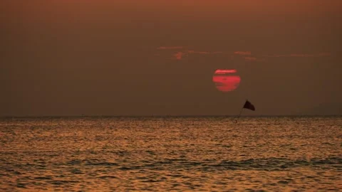 Dramatic evening sun over tropical sea with scary clouds  and red flag Stock Footage 332035592