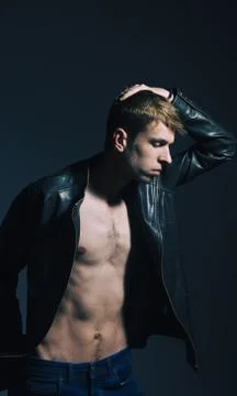Dramatic fashion model in leather jacket on black background. Stock Photos