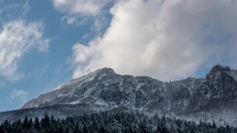 Dramatic fast moving clouds pass over a snowy mountain, Velky Rozsutec Stock Footage 167838682