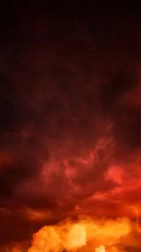 Dramatic fiery red and orange stormy sky with dark clouds and bright smoke,.. Stock Photos