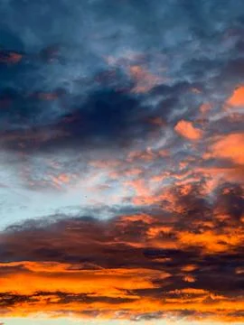 Dramatic Fiery Sunset Clouds Against Deep Blue Evening Sky 스톡 사진
