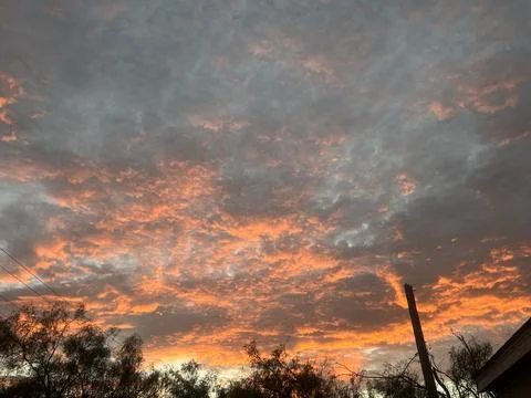 Dramatic Fiery Sunset Clouds Over Rural Tree Line Stock Photos