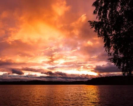 Dramatic fire red sunset over a lake Stock Photos