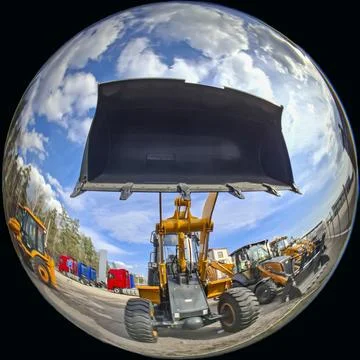 Dramatic fish eye view of a yellow industrial wheel loader parked under a b.. Stock-Fotos
