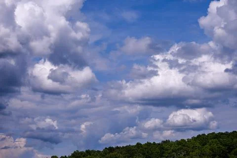 Dramatic fluffy cloudscape and deep blue sky Stock Photos