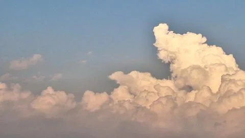 Dramatic Fluffy White Clouds with Golden Sunlight Glow. 库存照片