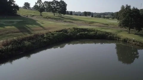 Dramatic fly by of golfer teeing off on par three Stock Footage 79967435