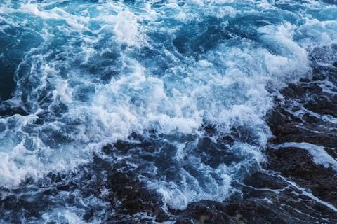 Dramatic foamy sea top view near the rocky shoreline Stock Photos