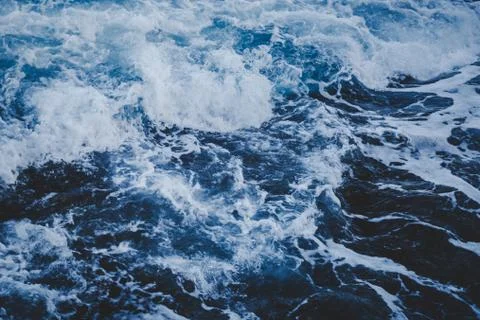Dramatic foamy sea top view near the rocky shoreline, toned abstract image Stock Photos