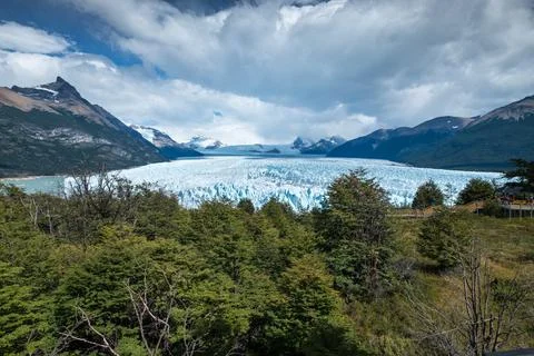 Dramatic Glacier Landscape Under Cloudy Sky with Forest and Mountains Stock Photos