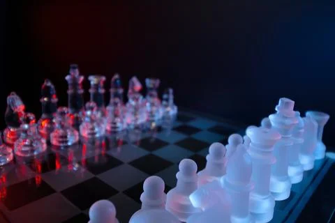 Dramatic glass chess set with red and blue lighting symbolizing strategy, compet Stock-Fotos