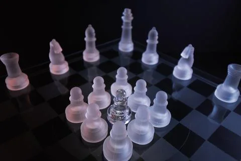 Dramatic glass chess set with white lighting symbolizing oppression, intimidació Stock-Fotos