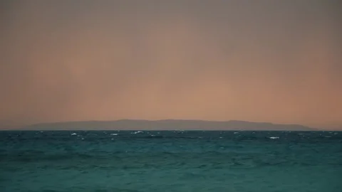 Dramatic Glow Stormy Ocean Waves Island on Horizon 3 Stock Footage 80199404