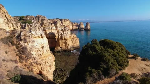 Dramatic Golden Cliffs of Algarve Coast Against Azure Ocean Under Clear Blu.. Stock Footage 310551589