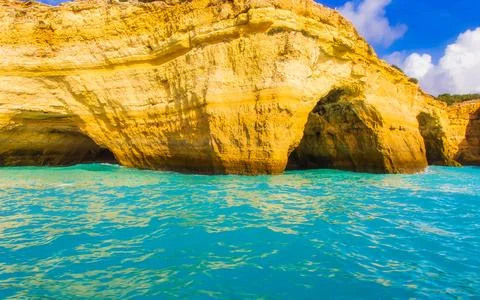 Dramatic Golden Cliffs With Sea Caves And Turquoise Ocean Water Landscape Stock Photos