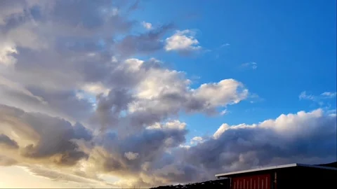 Dramatic Golden Hour Clouds over Modern Rooftop - 4K Video stock 334628204