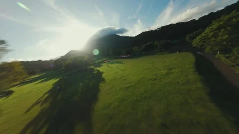 Dramatic Golden Hour FPV Drone Flight Over Event Tents and Lush Mountains Stock Footage 319368163