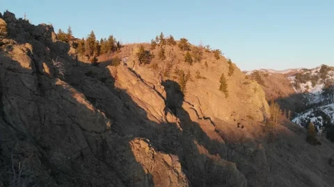 Dramatic golden light on rocky mountain side 스톡 동영상 166437002