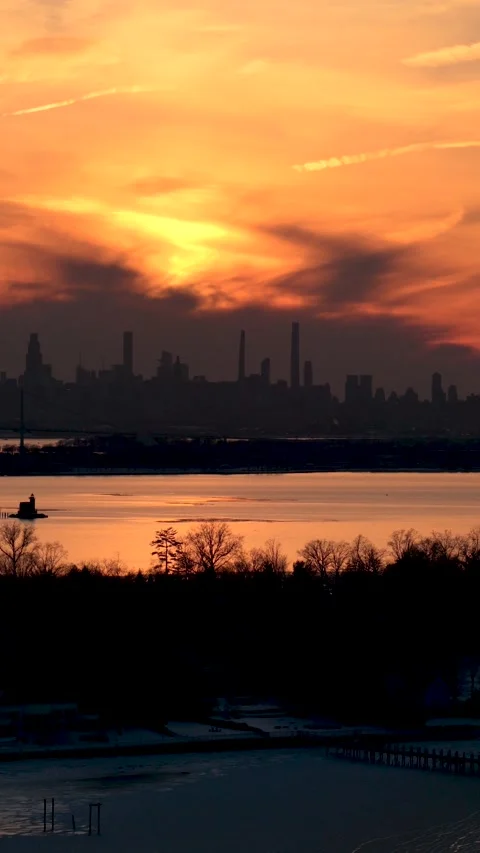 Dramatic golden sky glowing at sunset over the silhouette of the new york city Stock Footage 329275681