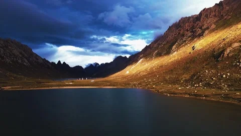 Dramatic Golden Sunlight Illuminating Rugged Mountains and Serene Lake China Stock Footage 346333773