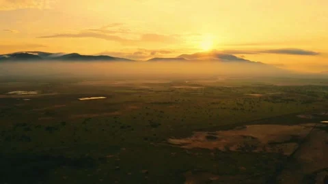 Dramatic Golden Sunrise or Sunset Over Vast Valley, Mountains, and Wetlands Stock Footage 319980639