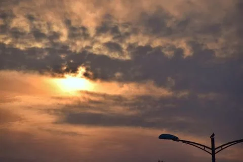Dramatic golden sunset behind textured clouds Stock Photos