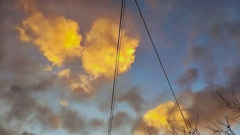 Dramatic golden sunset clouds in blue evening sky nature beauty concept Stockfoto's