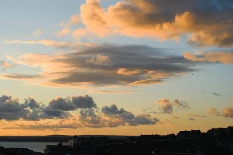 Dramatic Golden Sunset Clouds Over Coastal Town Skyline in Cornwall Stock Photos