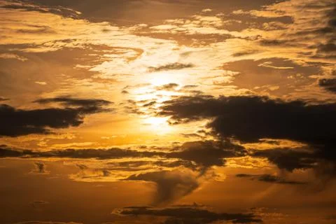 Dramatic Golden Sunset Cloudscape with Glowing Sunlight and Storm Clouds Stockfoto's