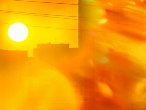 Dramatic Golden Sunset over Cityscape with Wires.  Sunbeams, Warm Sun Flare. Stock Photos