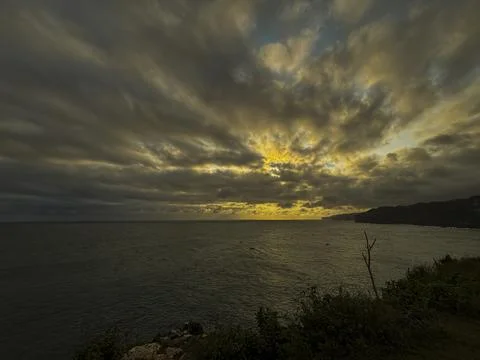 Dramatic Golden Sunset Over Cloudy Horizon Above Calm Sea Stock Photos
