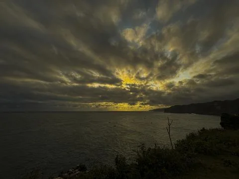 Dramatic Golden Sunset Over Cloudy Horizon Above Calm Sea Stock Photos
