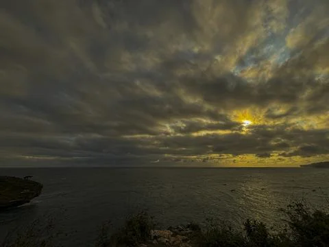 Dramatic Golden Sunset Over Cloudy Horizon Above Calm Sea Stock Photos
