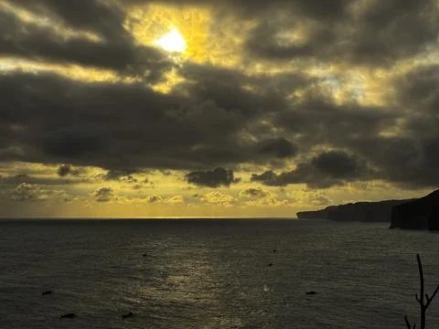 Dramatic Golden Sunset Over Cloudy Horizon Above Calm Sea Stock Photos