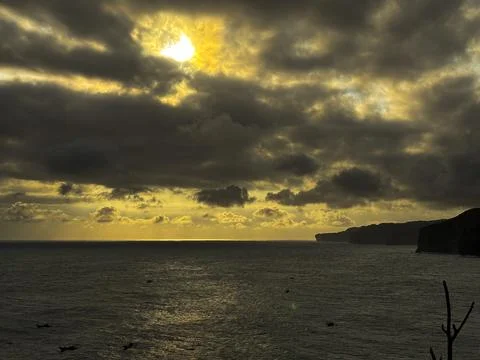 Dramatic Golden Sunset Over Cloudy Horizon Above Calm Sea Stock Photos