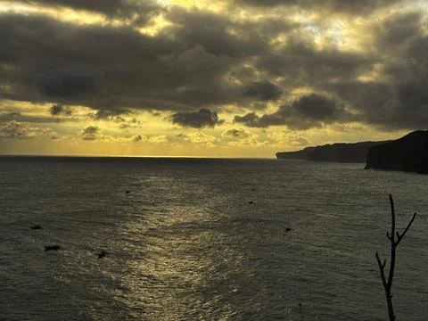 Dramatic Golden Sunset Over Cloudy Horizon Above Calm Sea Stock Photos