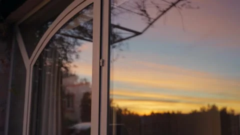 Dramatic golden sunset reflecting in a glass door with a soft, blurred Stock Footage 340010421